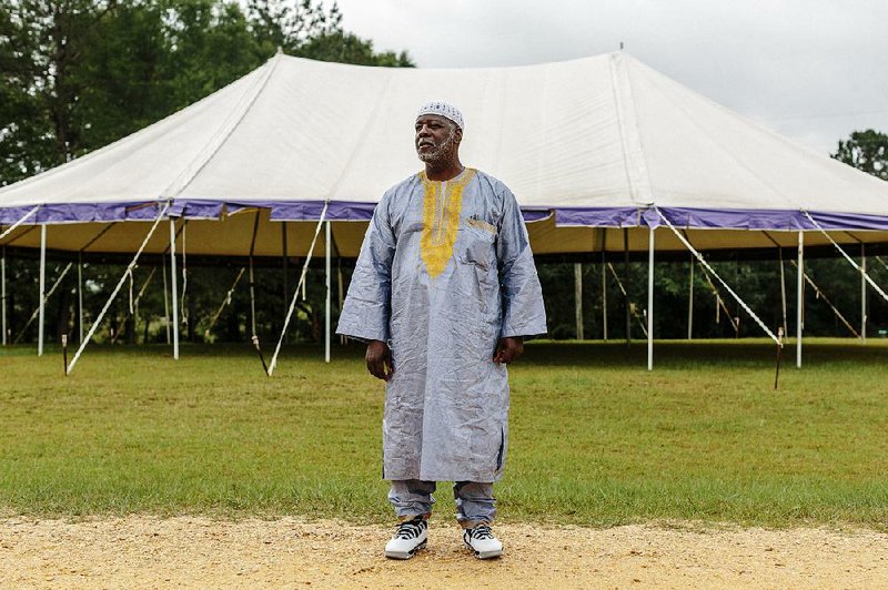 Shaheed Shabazz, who traveled from Winston-Salem, N.C., for a religious retreat at New Medinah, Miss., stands near a tented community bazaar, where he was selling homemade bean pies, essential oils and books on Islam. 