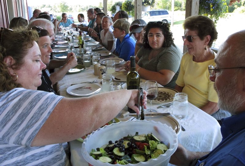 In this Aug. 1, 2017 photo, diners attend a weekly farm dinner at Valley Dream Farm in Cambridge, Vt., featuring produce from the farm and other Vermont made products. From California to food-loving Vermont, farmers are drawing customers to feast on foods raised in nearby fields. (AP Photo/Lisa Rathke)