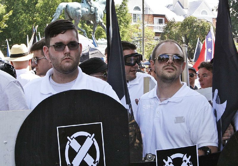 James Alex Fields Jr. (left) holds a black shield Saturday in Charlottesville, Va., hours before he was arrested in an attack on a crowd of protesters.