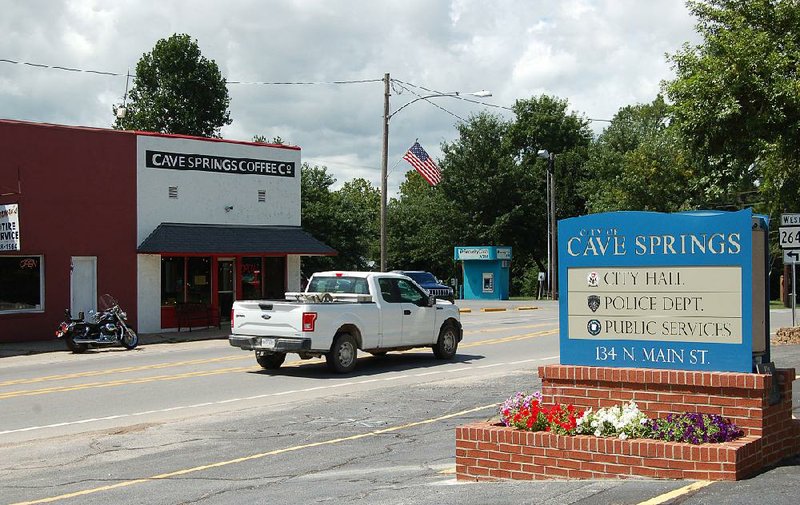 Traffic moves along Main Street in Cave Springs on Friday.
