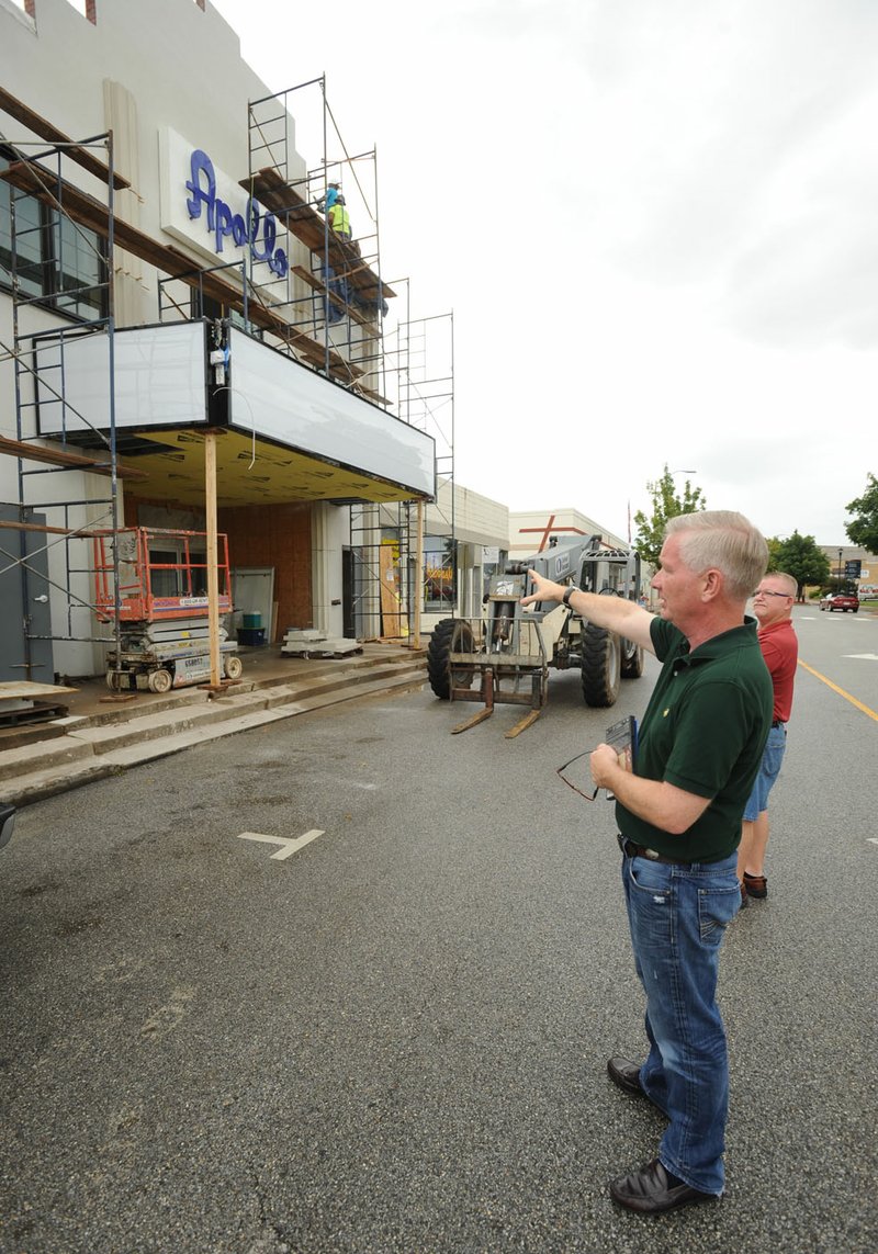Tom Lundstrum (center), The Apollo on Emma owner, speaks Friday with Terry Mason, owner of Mason’s Old Time Barber Shop, as workers continue to put the finishing touches on the building on Emma Avenue in Springdale. The event space plans to open Thursday.