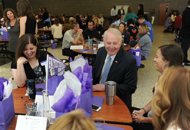 Steve Jacoby (center), interim principal at Fayetteville High School, speaks Thursday, Aug. 3, 2017, with Jessica Vest (from left), journalism teacher at FHS, Jackie Moore, oral communications teacher at FHS, and Monika Killion, cheer coach and geometry teacher at FHS, during new teacher orientation at Fayetteville High School.