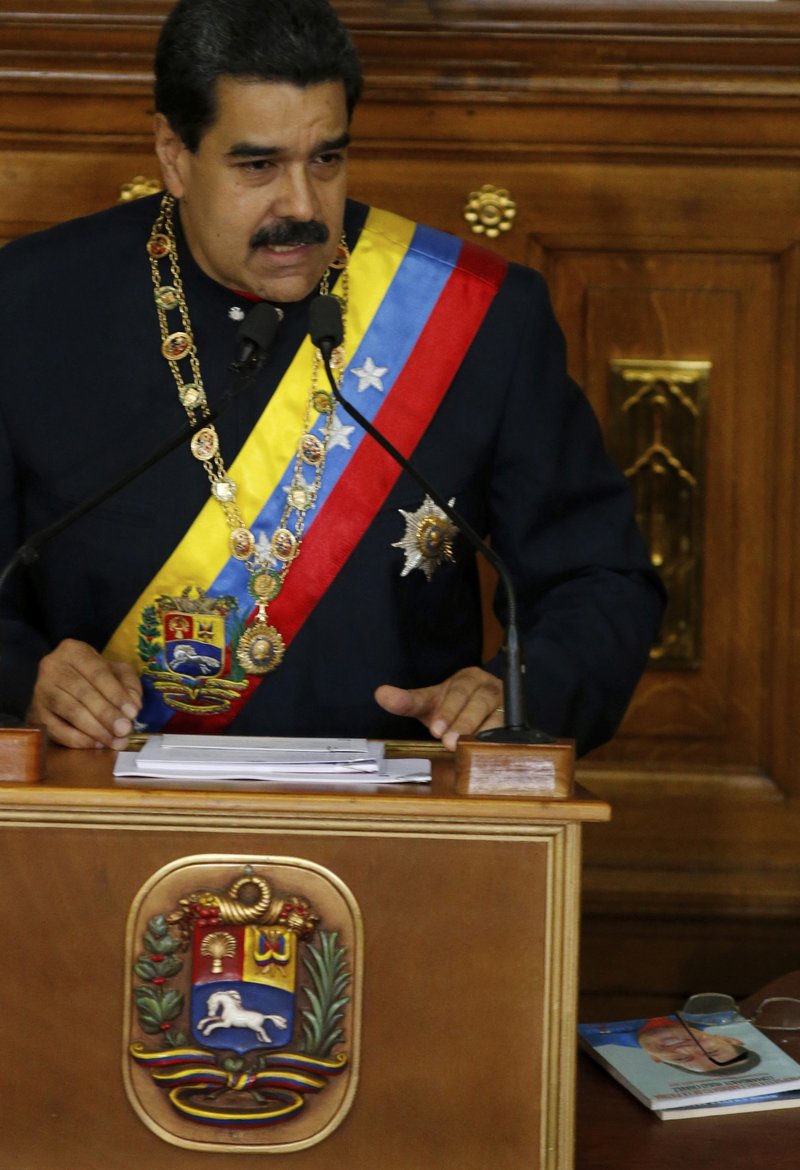 Venezuela's President Nicolas Maduro addresses Constitutional Assembly members at the National Assembly building in Caracas, Venezuela, Thursday, Aug. 10, 2017, as a book at his right shows the face of his late predecessor Hugo Chavez, which outlines Chavez's project coined "Plan de Patria" or "Plan Homeland." Maduro pushed for the creation of the constitutional assembly to rewrite the constitution. 