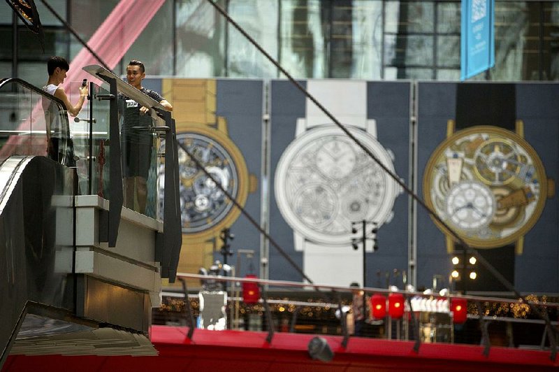 A man poses for a photo at an upscale shopping mall in Beijing on Aug. 8. President Donald Trump signed an executive order Monday asking his trade office to consider seeking a trade investigation of China for the alleged theft of American technology and intellectual property.