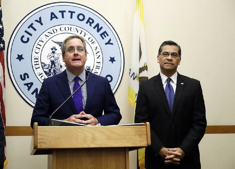 San Francisco City Attorney Dennis Herrera (left), accompanied at a City Hall news conference by California Attorney General Xavier Becerra, speaks Monday about restrictions on public safety grants.