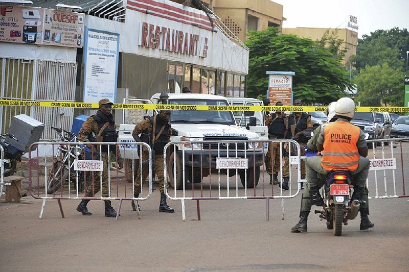 Security forces stand guard Monday at the site of an attack by gunmen in Ouagadougou, Burkina Faso.