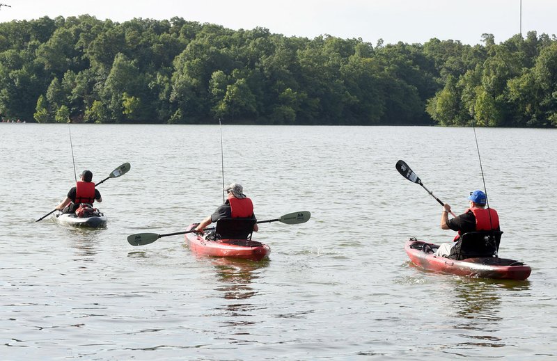 Paddlers with Heroes on the Water head out on Lake Fayetteville for a morning of fishing on July 8. The organization offers kayak fishing trips to veterans, firefighters and law enforcement at no charge.