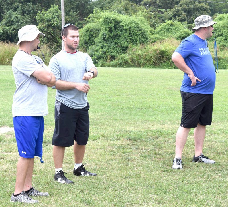 Photo by Mike Eckels The new Decatur Bulldog football coaching staff runs their players through the Aug 3. practice session at Bulldog Stadium in Decatur. Ryan Woolard (left), the new head coach, will be assisted by Cody Reid (center), linebacker coach, and Sheldon McKinzie, defensive coach.