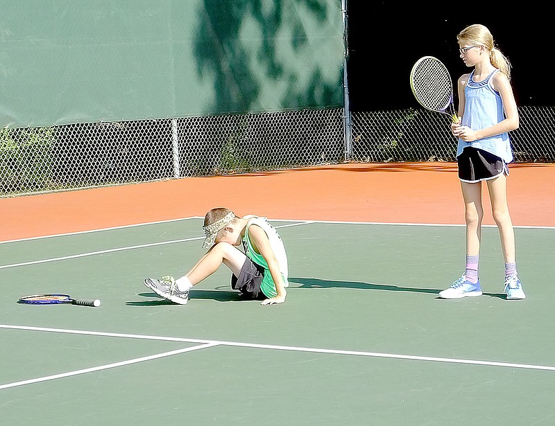 Lynn Atkins/The Weekly Vista Clayton Brock reacts to a missed shot while Anna Kedrowski looks on at Tennis Camp at the Riordan Hall Tennis Center last week. It was the third and last session of Tennis Camp and attracted about 20 kids aged 9 through 18, tennis pro Pat Hennessy said. This week, members of the Bentonville High School tennis team will work out on the Bella Vista courts.