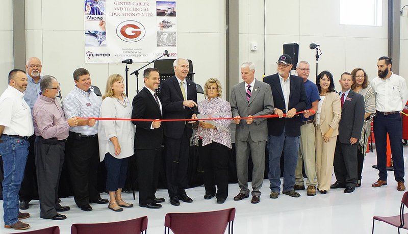 Photo by Randy Moll Arkansas Governor Asa Hutchinson cut the ribbon to open the new Gentry Career and Technical Education Center at the high school on Tuesday, Aug. 8. Joining him were Rep. Steve Womack, teachers, school administrators and staff, school board members, Gentry&#8217;s mayor and Chamber of Commerce members, and the buildings designers and engineers.