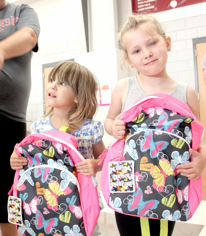 LYNN KUTTER ENTERPRISE-LEADER Zoe Harriman, 3, and Aubrey Yates, 4, of Lincoln, show off their new backpacks they received at the Lincoln Back to School Bonanza. Aubrey will be in the pre-kindgarten program at Lincoln Elementary.