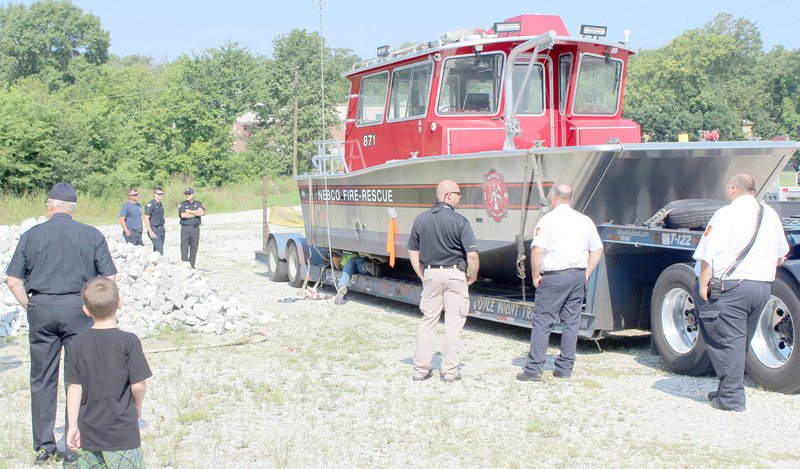 TIMES photograph by Keith Bryant NEBCO firefighters and command staff look over the department&#8217;s freshly-acquired fire-rescue boat.