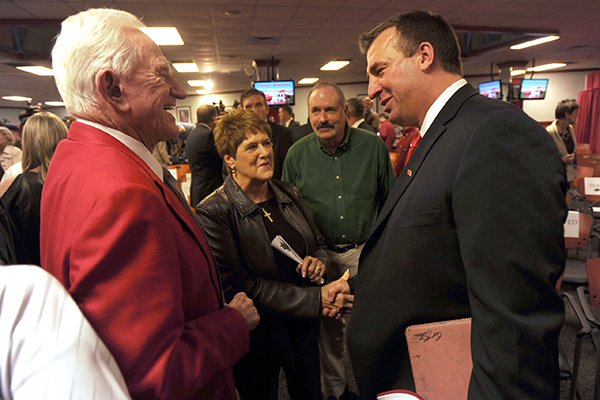 Former Arkansas athletics director Frank Broyles, left, speaks Wednesday, Dec. 5, 2012, with Bret Bielema, right, following a press conference to announce Bielema's hire as the University of Arkansas' football coach at the Broyles Athletic Complex on the UA campus in Fayetteville.
