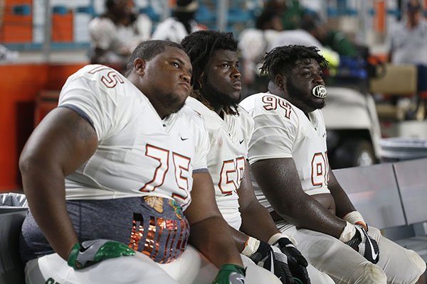 Florida A&M offensive lineman Keenen Anderson (75) linebacker Emilio Gibbs, center, and defensive tackle Javon Hunt (94) watch from the bench during the final minutes of an NCAA college football game against Miami, Saturday, Sept. 3, 2016 in Miami Gardens, Fla. Miami defeated Florida A&M 70-3. (AP Photo/Wilfredo Lee)
