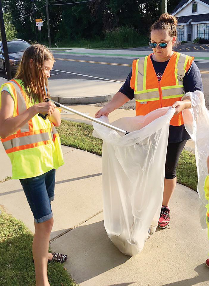 Abbi Johnson, left, cleans up a roadside in Pope County with Kristal Ward, a co-leader of the Better Together 4-H Club.