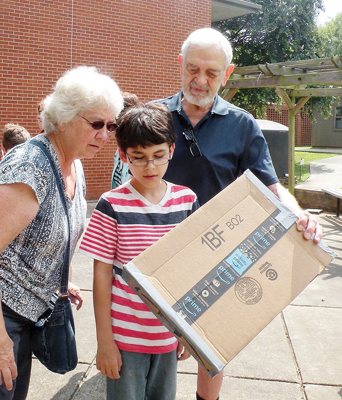 Henry F. Bryant of Conway, right, holds a pinhole projection box for Linda Matchett of Vilonia, left, and her 11-year-old grandson, Ethan Nash, also of Vilonia, to view the sun. All three attended Saturday’s program, Countdown to Eclipse, at the Faulkner County Library in Conway. A pinhole projection box such as this one offers an indirect method of viewing Monday’s solar eclipse if special eclipse glasses are not available.