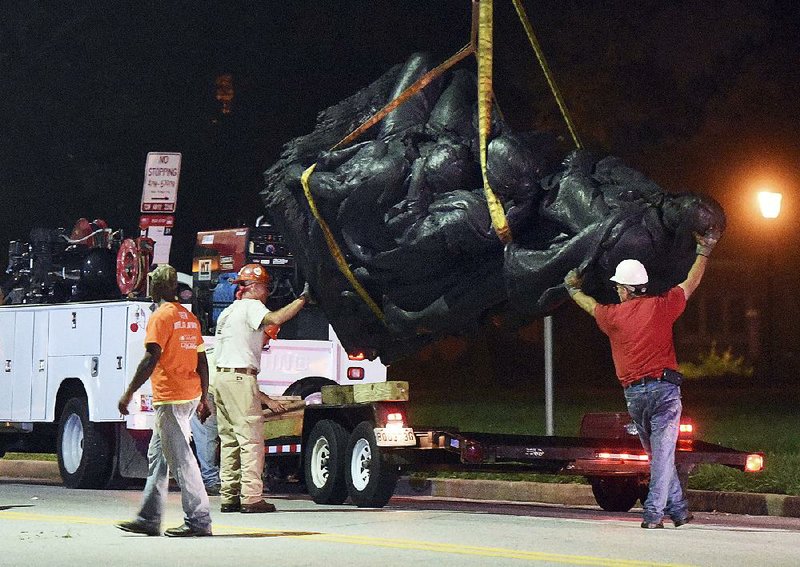 Workers remove a monument dedicated to the Confederate Women of Maryland early Wednesday after it was taken down in Baltimore.
