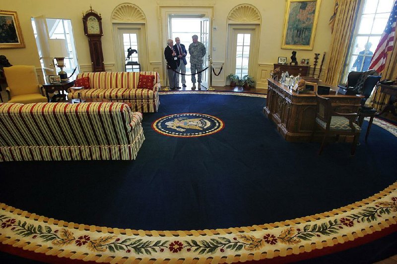 Arkansas Democrat-Gazette/BENJAMIN KRAIN 11-12-09
Clinton Presidential Center tour guide Bob Gee, left, discusses the history of the Oval Office with Jim Hannon, center, and Gen. Michael Wlash, right, both from Mississippi, during a tour of the library, which celebrates its fifth anniversary this weekend.