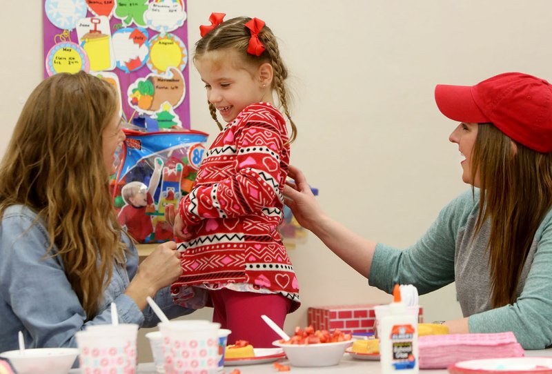 Ruby Seay laughs as she makes a strawberry shortcake Feb. 14 with Jessica Luckett (left) with the Arkansas Support Network, and Ferrin Webb, a senior student and preschool teacher at the University of Arkansas Autism Research Clinic. The Valentine’s Day party was held on the campus in Fayetteville. Proceeds from “The Great Tailgate for Inclusion” on Sept. 8 will benefit Arkansas Support Network.