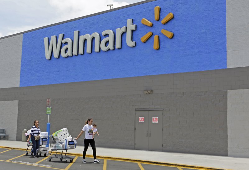 In this Thursday, June 1, 2017, photo, customers walk out of a Walmart store in Hialeah Gardens, Fla. Wal-Mart Stores, Inc. reports earnings, Thursday, Aug. 17, 2017. (AP Photo/Alan Diaz)
