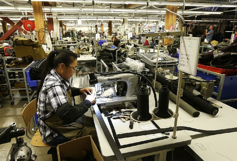 A worker stitches a belt at the C.C. Filson Co. plant in Seattle. The Federal Reserve reported a drop in factory production last month.
