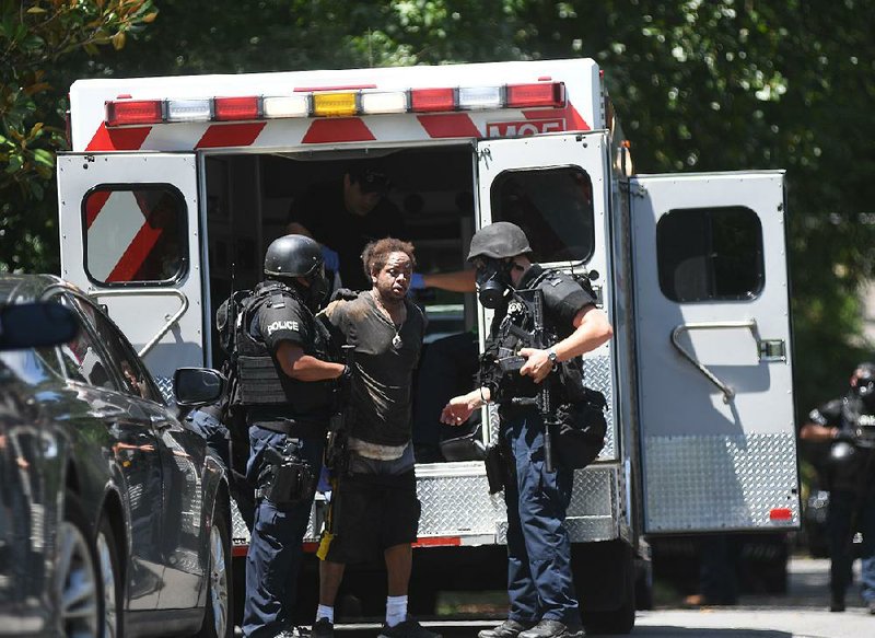 Hot Springs police officers arrest burglary suspect Andre Flowers after a standoff with police at 213 Lawson St. on Wednesday.