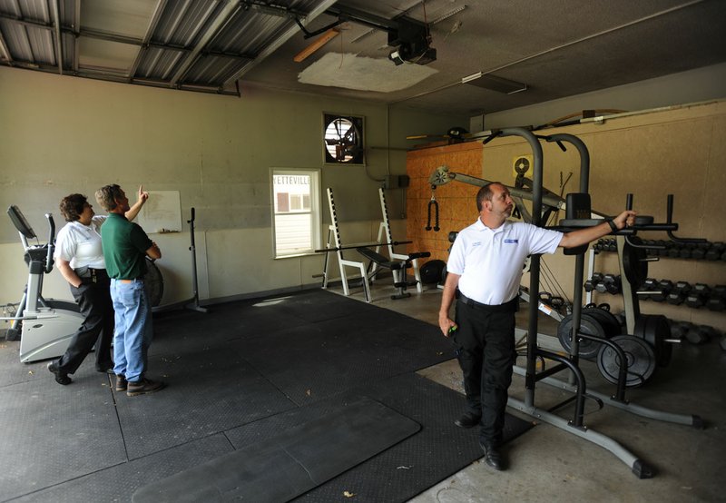 Becky Stewart (from left), chief for Central Emergency Medical Services, joins Owen McAdoo, finance director, and Steve Harrison, assistant chief, in examining the vehicle bay Thursday at Fayetteville Fire Department's Fire Prevention Bureau, 833 N. Crossover Road. The ambulance authority executive committee is in the process of purchasing the structure for use as a station for Central EMS after Fayetteville's City Council voted Tuesday to sell the facility.