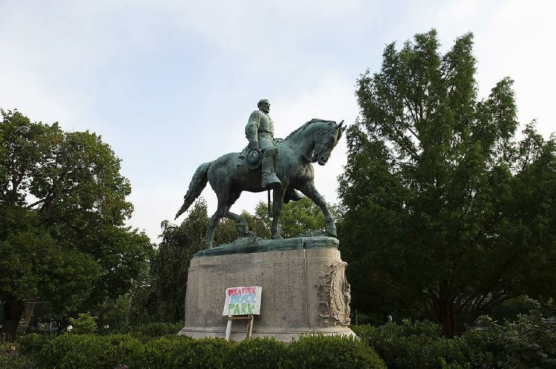 A sign bearing the words Heather Heyer Park sits Friday at the base of the statue of Confederate Gen. Robert E. Lee in Emancipation Park in Charlottesville, Va. Heyer was killed last weekend while protesting a white nationalist rally in Charlottesville.