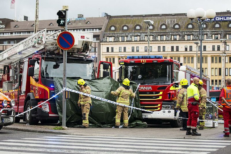 Rescue personnel work at the scene Friday in Turku, Finland, where a man with a large knife stabbed several people, two fatally.