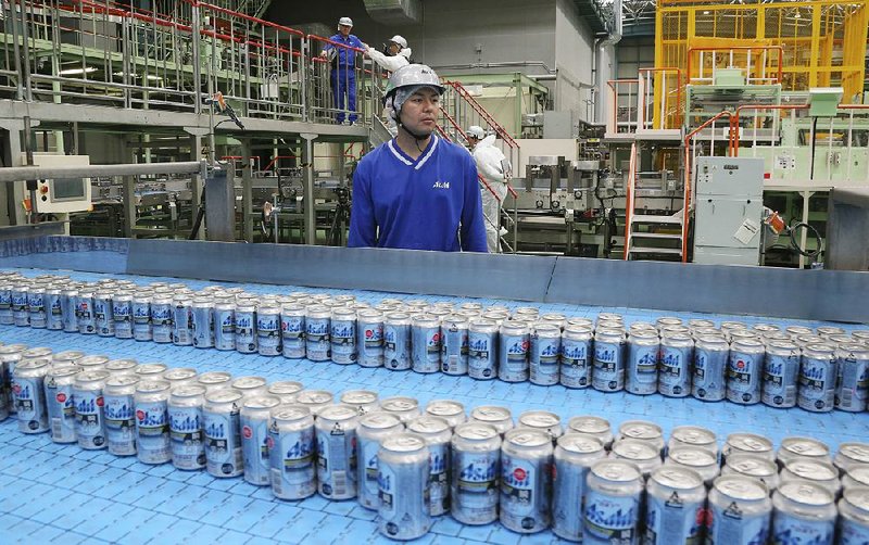Asahi Breweries plant manager Shinichi Uno watches the production line at an Asahi Breweries factory in Moriya near Tokyo in late May.
