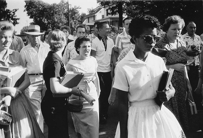 Students of Central High School in Little Rock shout insults at Elizabeth Eckford walking past a line of National Guardsmen, not shown, who blocked the main entrance of the school on Sept. 4, 1957.