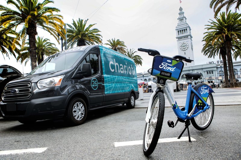 This Thursday, Sept. 8, 2016, file photo taken in San Francisco and provided by Ford Motor Company shows a Ford Transit passenger van operated by Chariot shuttle service and a bicycle operated by bike-share company Motivate. 