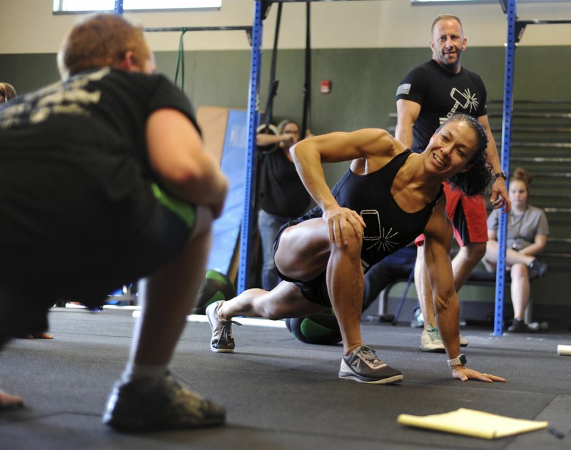 Fitness trainers Jennifer and Lee Kelly, owners of Crossfit NWA, work Wednesday with teens during a Training, Health, Opportunity, Responsibility session at the Benton County Sheriff’s Office in Bentonville. THOR participants are juveniles who are ordered by a judge to take part in the program to build self-esteem, fitness and teamwork skills.