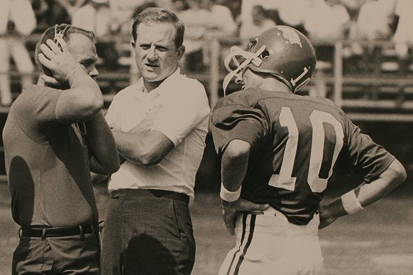 Arkansas coach Frank Broyles (center) and quarterback Bill Montgomery (10) interact with an unidentified assistant coach during a 1969 game in Little Rock. 