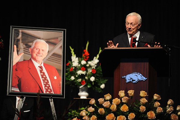 Jerry Jones, former Arkansas player and owner of the Dallas Cowboys, speaks alongside a portrait of Frank Broyles Saturday, Aug. 19, 2017, during a celebration in Bud Walton Arena on the University of Arkansas campus in Fayetteville for the life of Frank Broyles, the former coach and athletics director, who died Monday at 92.
