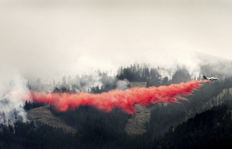 A plane drops fire retardant Friday on flames creeping toward the Bitterroot Valley in Missoula, Mont.