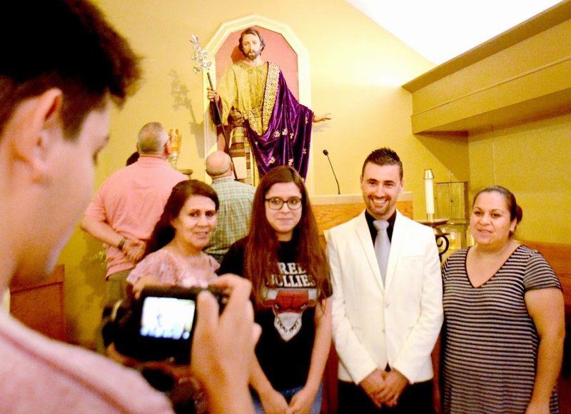Janelle Jessen/Siloam Sunday Parishioners posed for a picture with artist Angel Pantoja in front of a newly installed sculpture of Joseph after a special mass on Tuesday, held at St. Mary Catholic Church in Siloam Springs. Pantoja, who is from Spain, created three sculptures for the church and they were unveiled Monday.