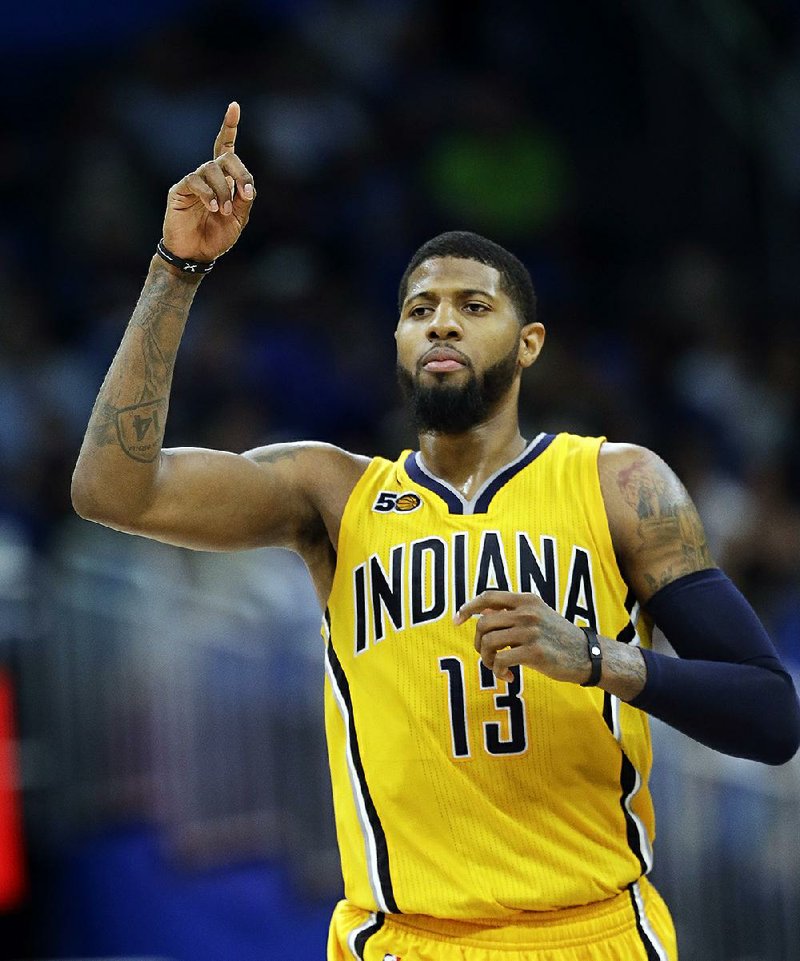 Paul George gestures after making a 3-point basket against the Orlando Magic during an NBA basketball game in Orlando, Fla.