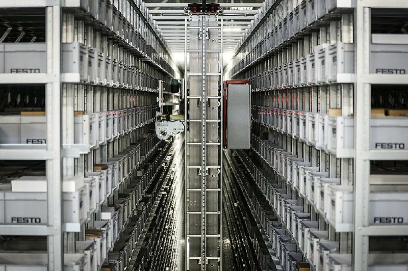 A robotic conveyor uses laser guides to sort through materials storage at Festo’s distribution facility in Mason, Ohio, in May.