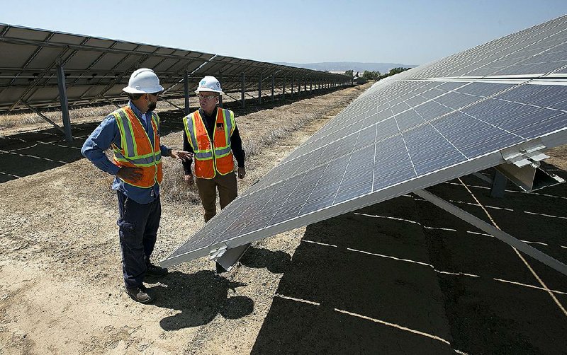 Solar tech Joshua Valdez (left) and senior plant manager Tim Wisdom confer after a walk-through of a Pacific Gas and Electric solar plant on Thursday in Vacaville, Calif.
