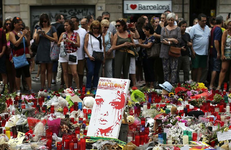 People pay their respects at a memorial Sunday for the people killed and wounded during a terror attack last week in Barcelona, Spain.