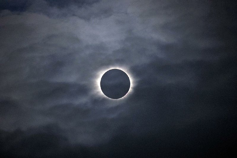 Cloudy weather obscures the total effect of a solar eclipse in this photo taken in 2015 on the Faeroe Islands.