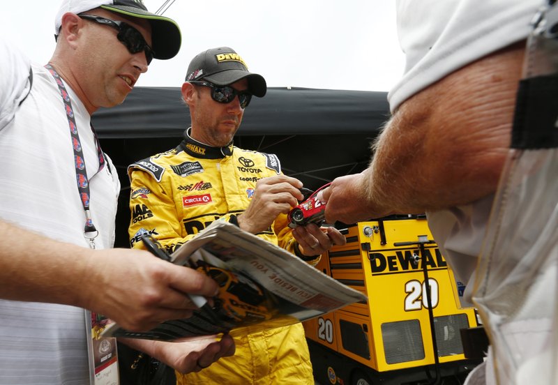 Driver Matt Kenseth signs autographs for fans after practice for the NASCAR Monster Energy Cup Series auto race, Friday, Aug. 18, 2017, in Bristol, Tenn. 