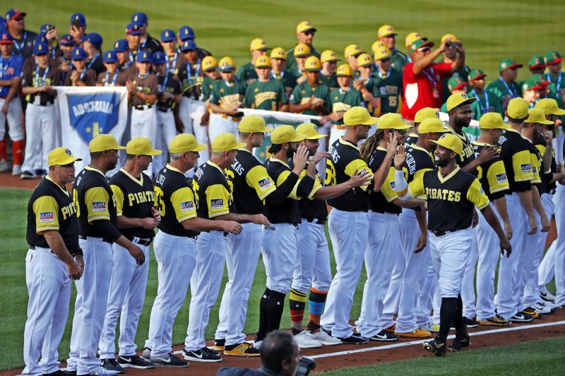 Pittsburgh Pirates' Andrew McCutchen, lower right, is introduced as Little League World Series teams, rear, from around the world line the infield before the Little League Classic baseball game between the Pirates and the St. Louis Cardinals at Bowman Field in Williamsport, Pa., Sunday, Aug. 20, 2017. (AP Photo/Gene J. Puskar)