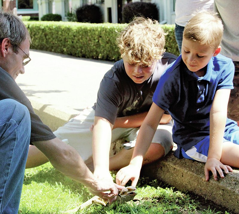 The Sentinel-Record/Grace Brown From left, Boone Weaver talks to Luke Griffith, 12, and Gage Griffith, 8, of Sheridan, about his bearded dragon, Spike, Saturday near Arlington Lawn.