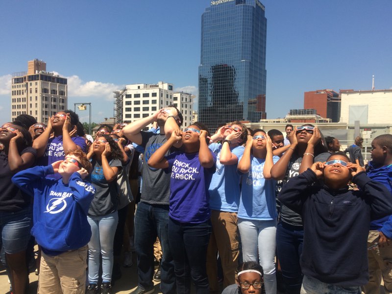 Seventh- and eighth-graders from eStem Public Charter Junior High School check out the eclipse from a parking lot rooftop in downtown Little Rock on Monday, Aug. 21, 2017.