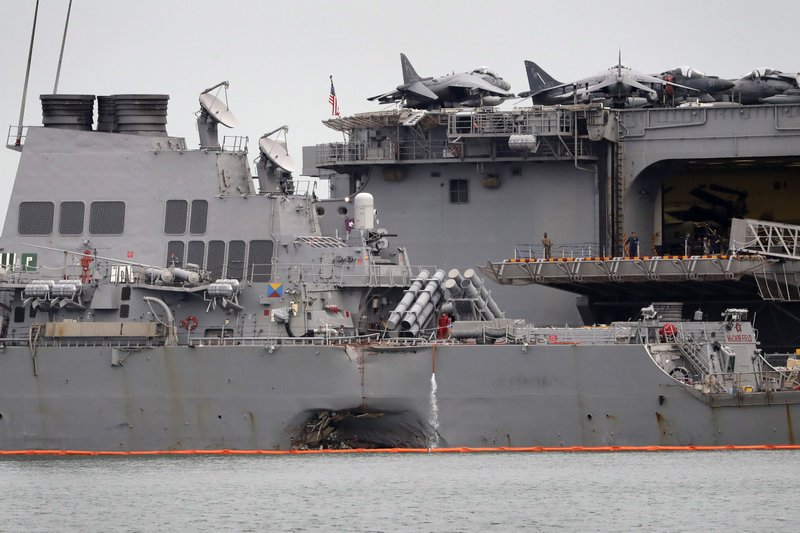 The damaged port aft hull of USS John S. McCain, left, is seen while docked next to USS America at Singapore's Changi naval base on Tuesday, Aug. 22, 2017 in Singapore. (AP Photo/Wong Maye-E)
