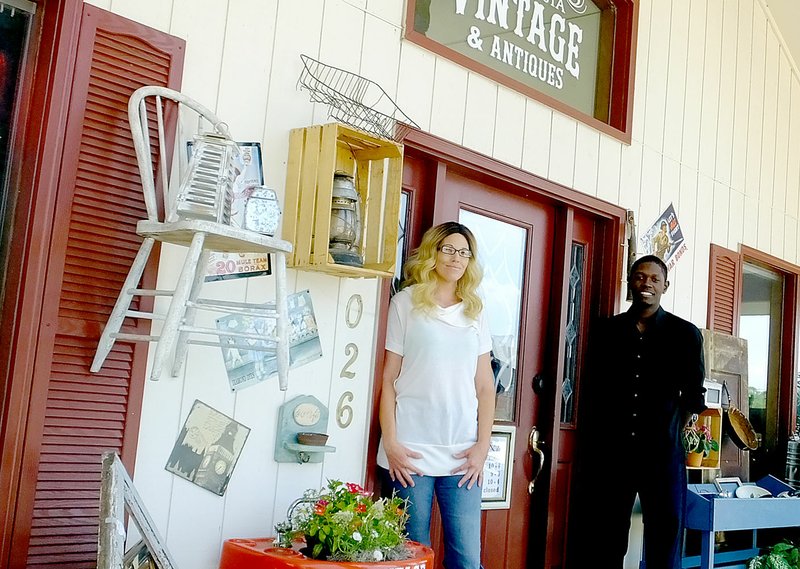 Lynn Atkins/The Weekly Vista Crystal Ordonez and Marcus Harris pose on the front porch of their new location. Bella Vista Vintage and Antiques has moved south and is located just off of Highway 71 near Kozy Heat.