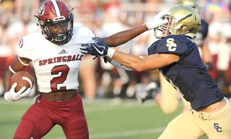 NWA Democrat-Gazette/ANDY SHUPE Springdale High receiver Kamond Robinson (2) stiff-arms Shiloh Christian cornerback Blake Thomson on Tuesday during a scrimmage at Champions Stadium in Springdale. Visit nwadg.com/photos for more photographs from the scrimmage.