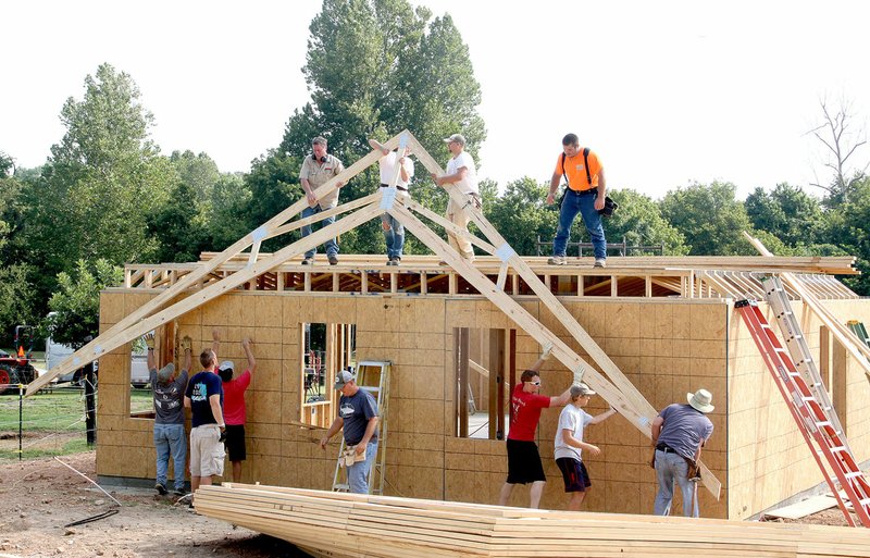 NWA Democrat-Gazette/LYNN KUTTER Trusses go up on the Eiter's house on Harmon Road near Fayetteville. Members of Prairie Grove Christian Church, plus volunteers from other churches in town, helped to build a home for the couple who lost almost everything during the April flooding.